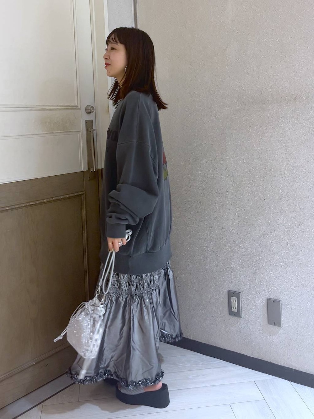 シルバー系のサンダル、シルバー系のショルダーバッグ、シルバー系のスカートを着用したレディースの夏コーディネートの2枚目の写真