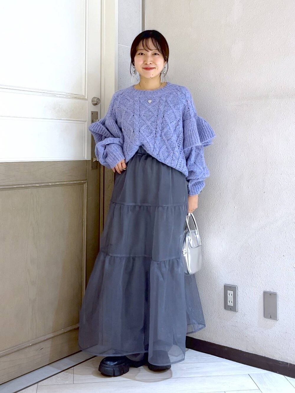 ブラック系のブーツ、パープル系のニット/セーター、シルバー系のボストンバッグを着用したレディースの秋コーディネートの2枚目の写真