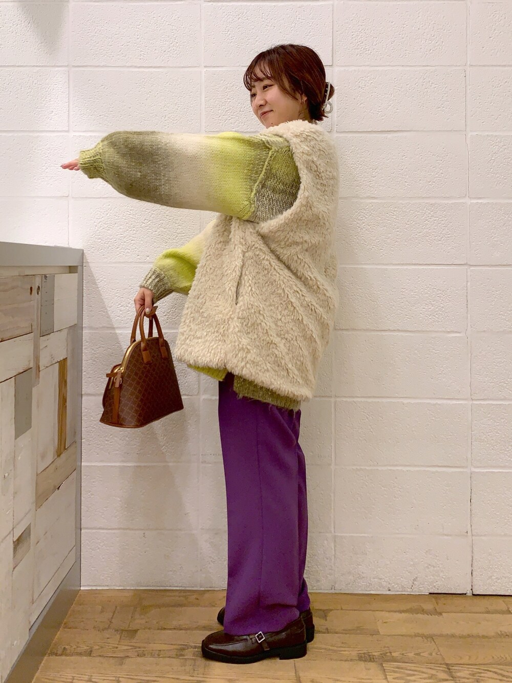 ホワイト系のジャケット/アウター、イエロー系のニット/セーター、パープル系のパンツを着用したレディースの秋コーディネートの2枚目の写真