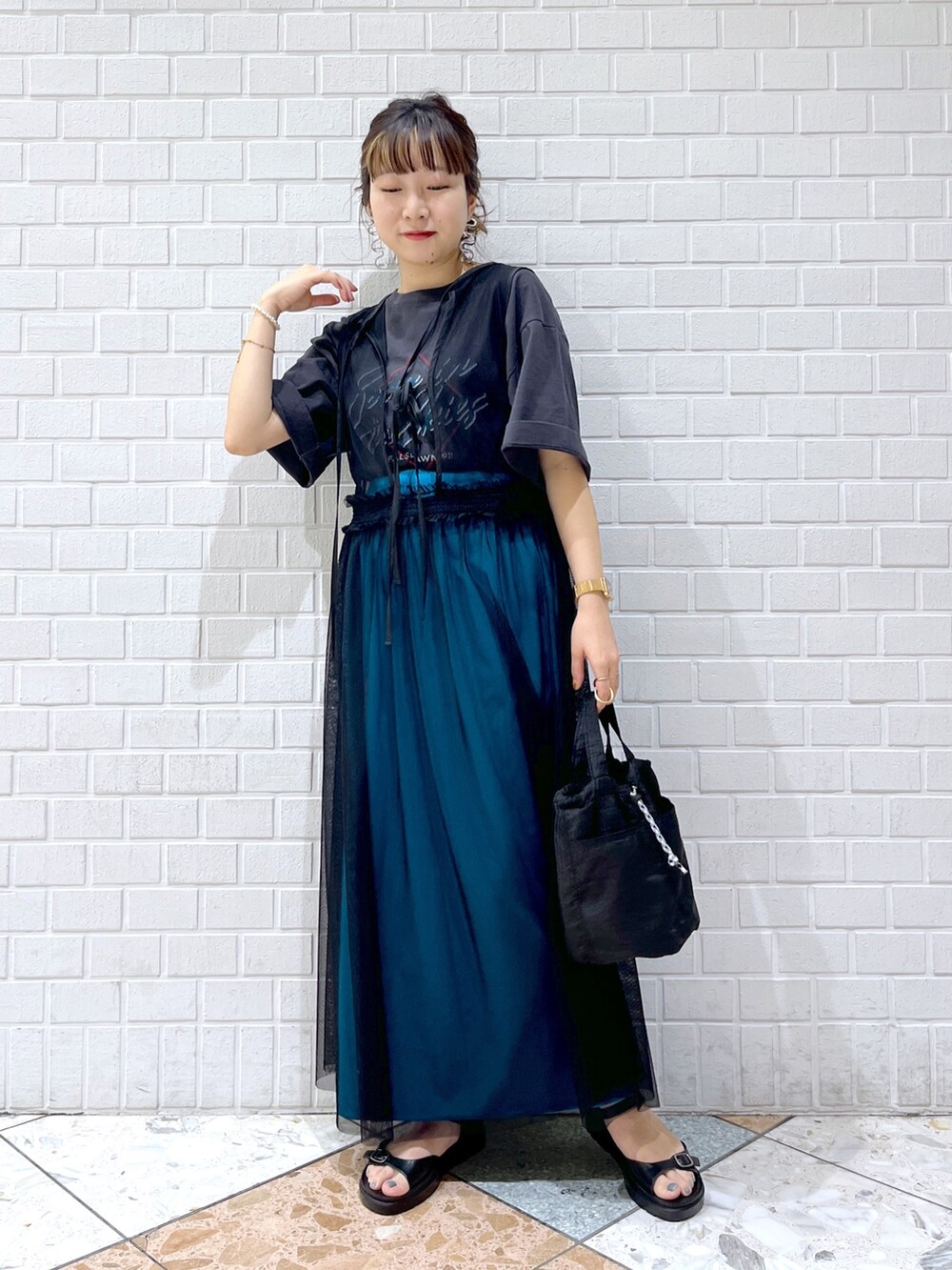 グレー系のTシャツ/カットソー、ブラック系のワンピース、ブルー系のスカートを着用したレディースの春コーディネートの3枚目の写真
