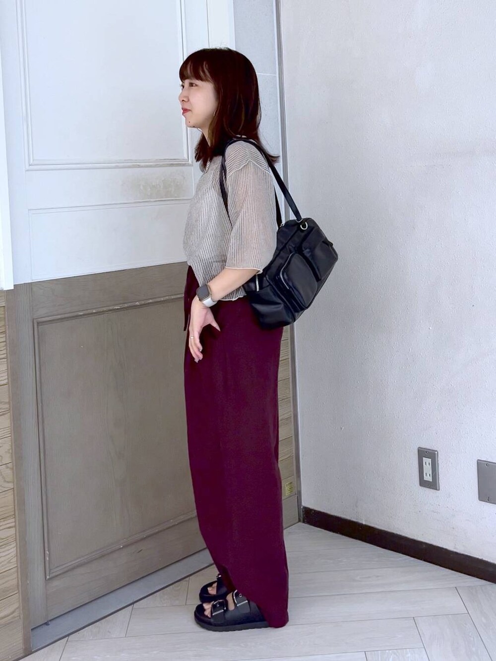 ブラック系のボストンバッグ、ホワイト系のTシャツ/カットソー、ブラウン系のスラックスを着用したレディースの夏コーディネートの4枚目の写真