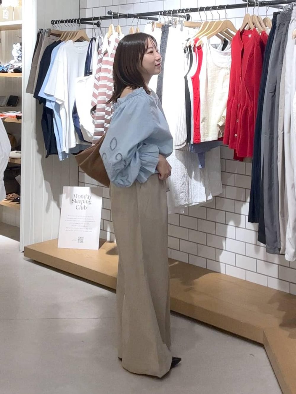 ブラック系のパンプス、ベージュ系のデニムパンツ、ブラウン系のショルダーバッグを着用したレディースの春コーディネートの2枚目の写真