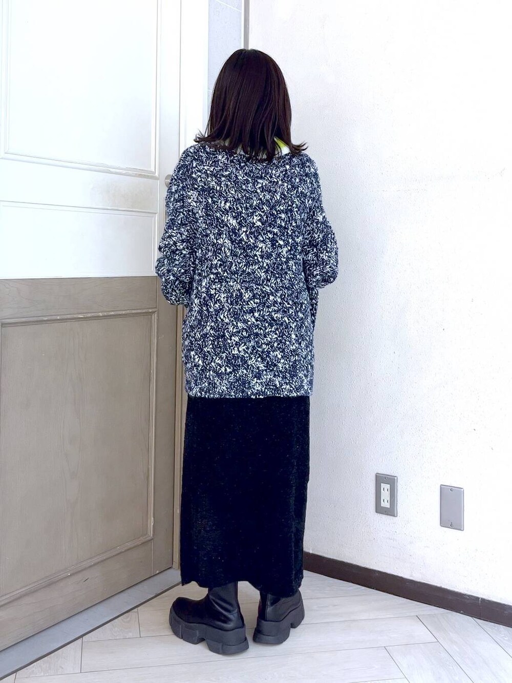 ブラック系のブーツ、ブルー系のニット/セーター、ホワイト系のショルダーバッグを着用したレディースの秋コーディネートの4枚目の写真