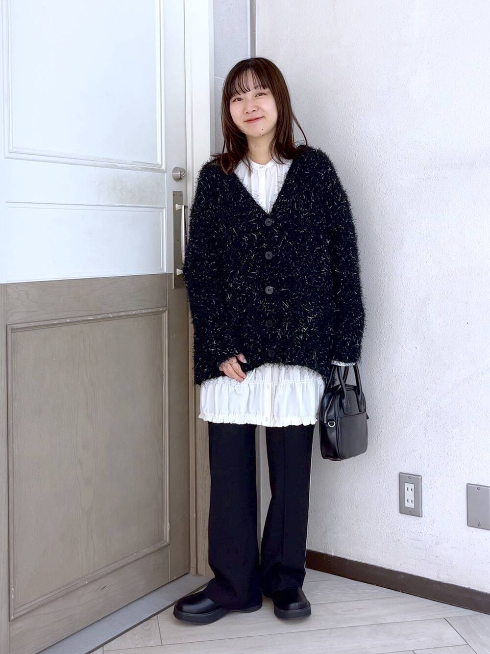 ブラック系のその他パンツ、ブラック系のブーツ、ブラック系のカーディガン/ボレロを着用したレディースの冬コーディネートの4枚目の写真