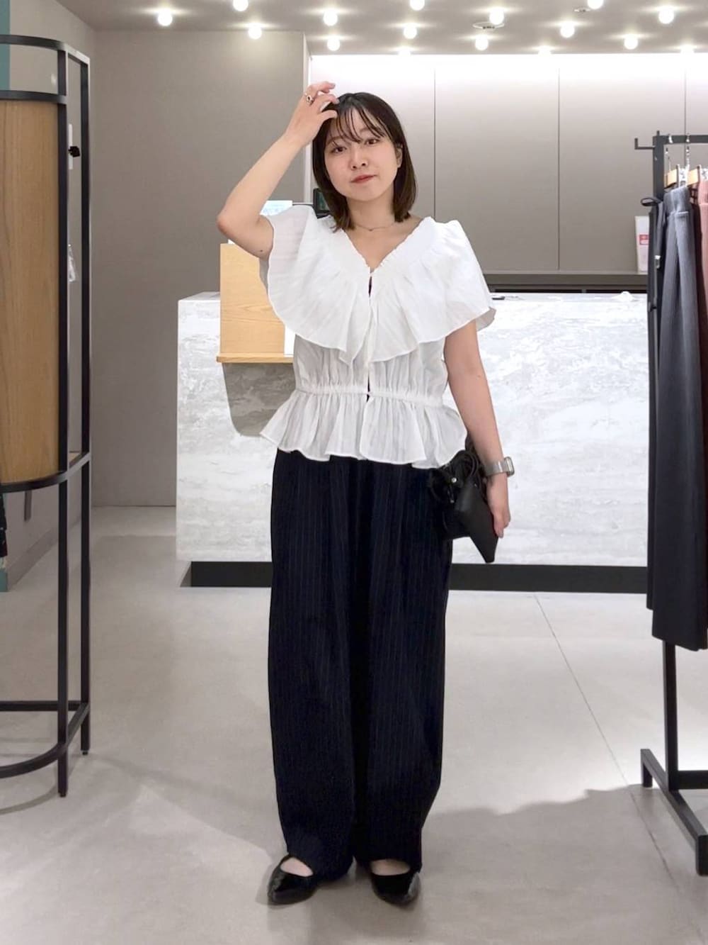 ブルー系のその他パンツ、ブラック系のパンプス、ブラック系のトートバッグを着用したレディースの春コーディネートの3枚目の写真