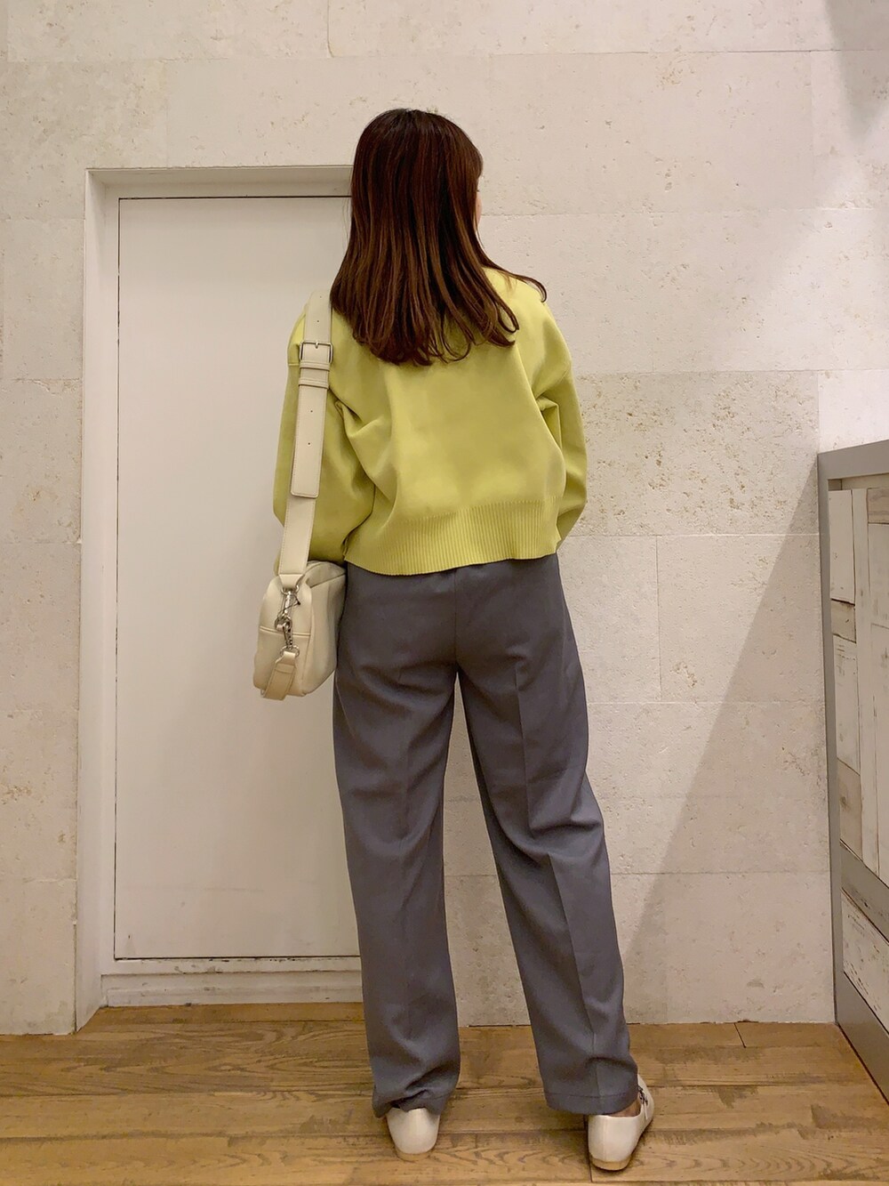 イエロー系のカーディガン/ボレロ、ブラック系のトップス、グレー系のパンツを着用したレディースの春コーディネートの3枚目の写真