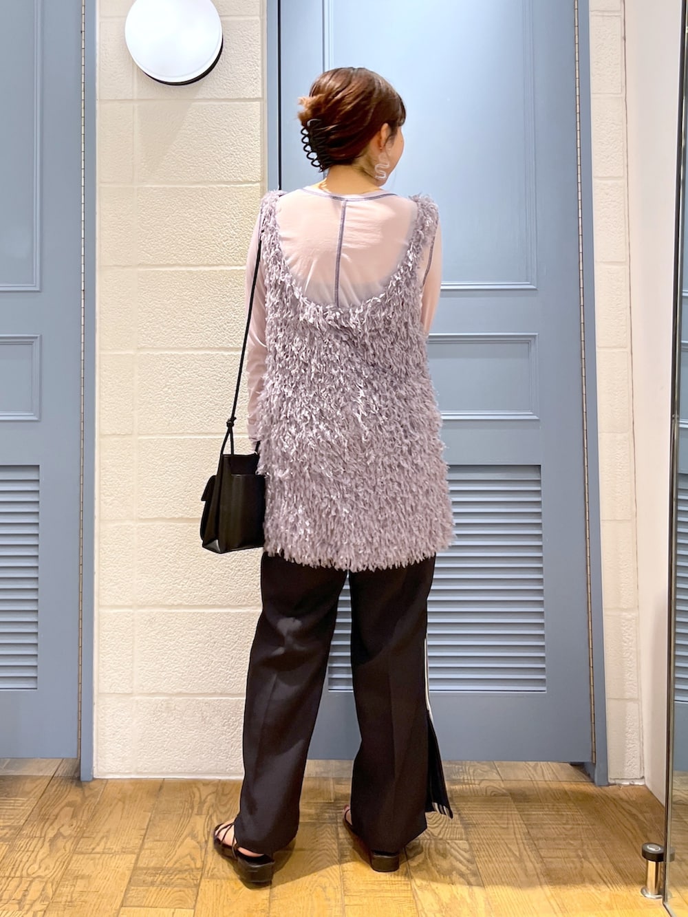 ブラック系のショルダーバッグ、ブラック系のパンツ、ブラック系のシューズを着用したレディースの秋コーディネートの3枚目の写真