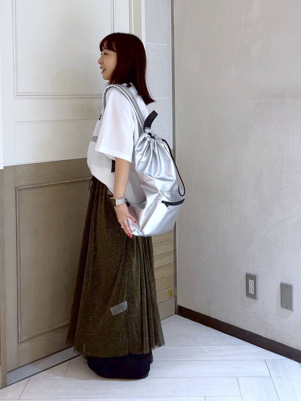 ブラック系のワンピース、シルバー系のショルダーバッグ、シルバー系のスニーカーを着用したレディースの夏コーディネートの3枚目の写真