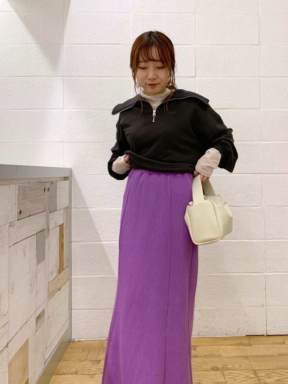 グレー系のトップス、ホワイト系のトップス、パープル系のスカートを着用したレディースの秋コーディネートの4枚目の写真