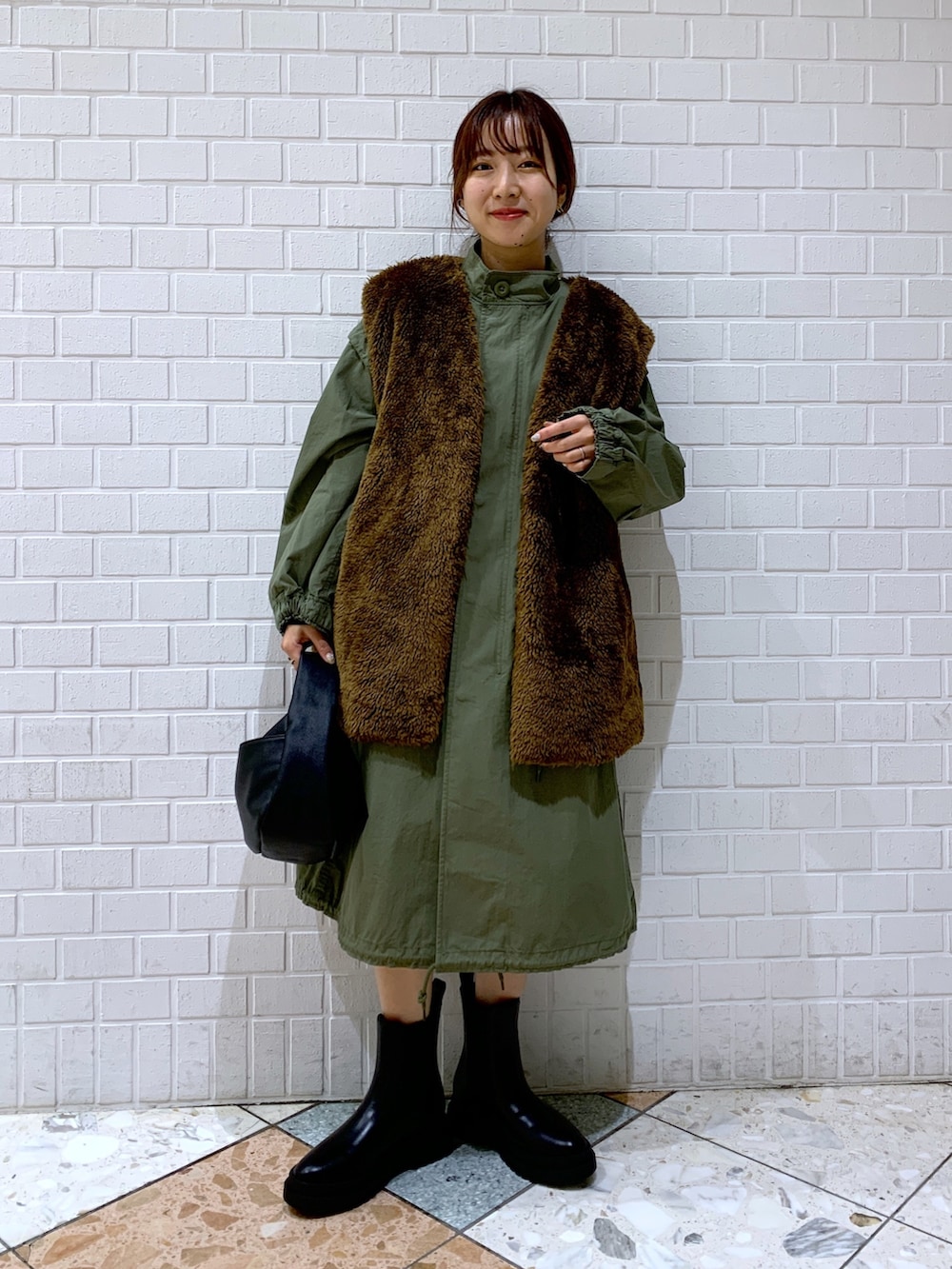 ブラウン系のジャケット/アウター、グリーン系のジャケット/アウター、ブラック系のショルダーバッグを着用したレディースの秋コーディネートの2枚目の写真