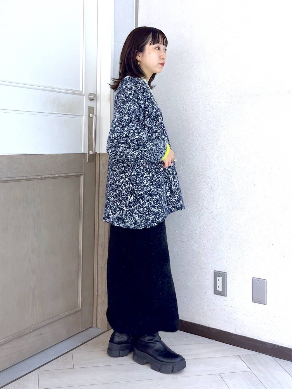 ブラック系のブーツ、ブルー系のニット/セーター、ホワイト系のショルダーバッグを着用したレディースの秋コーディネートの3枚目の写真