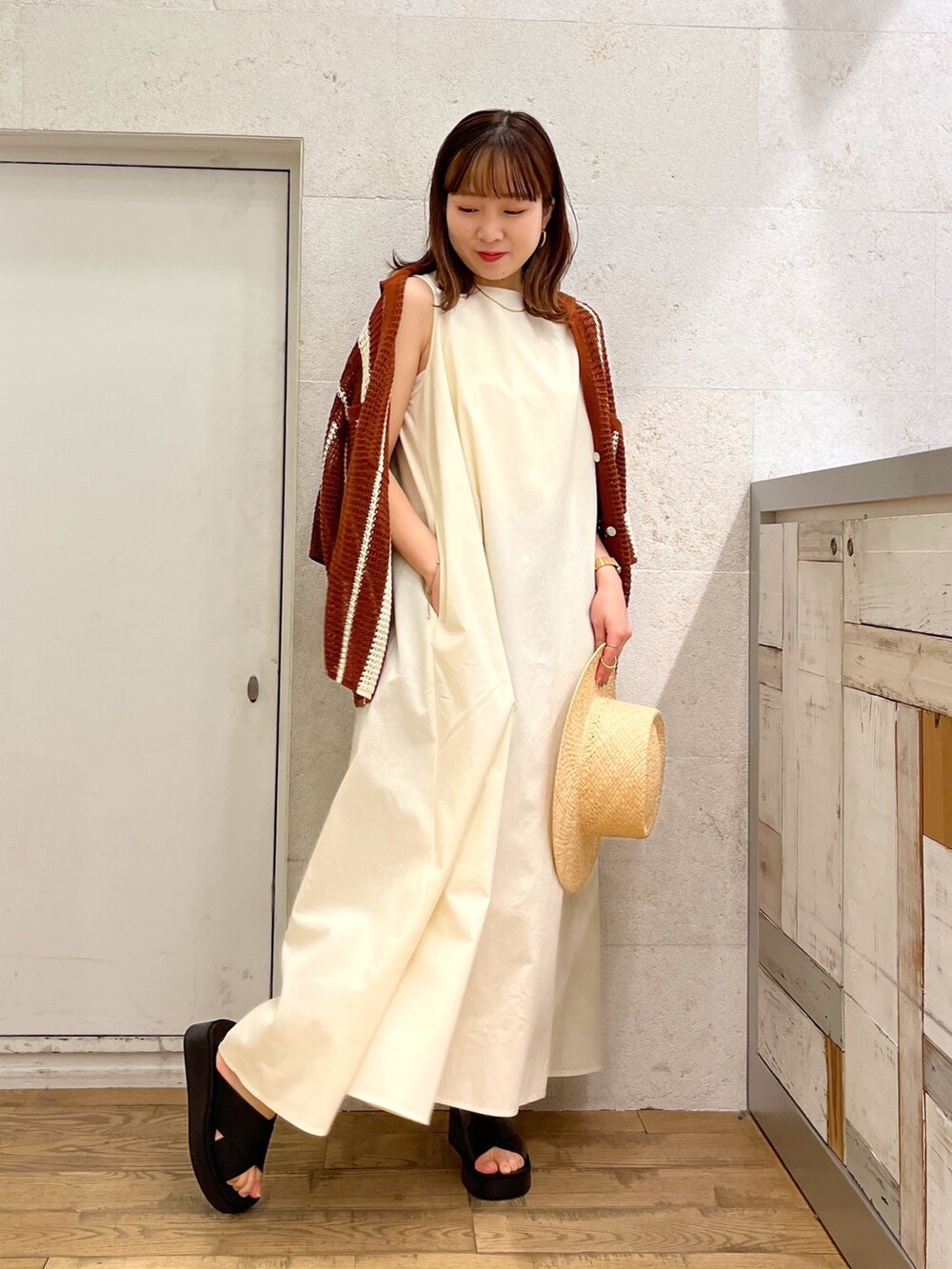 ホワイト系のワンピース、ブラウン系のトップス、ブラック系のシューズを着用したレディースの春コーディネートの4枚目の写真