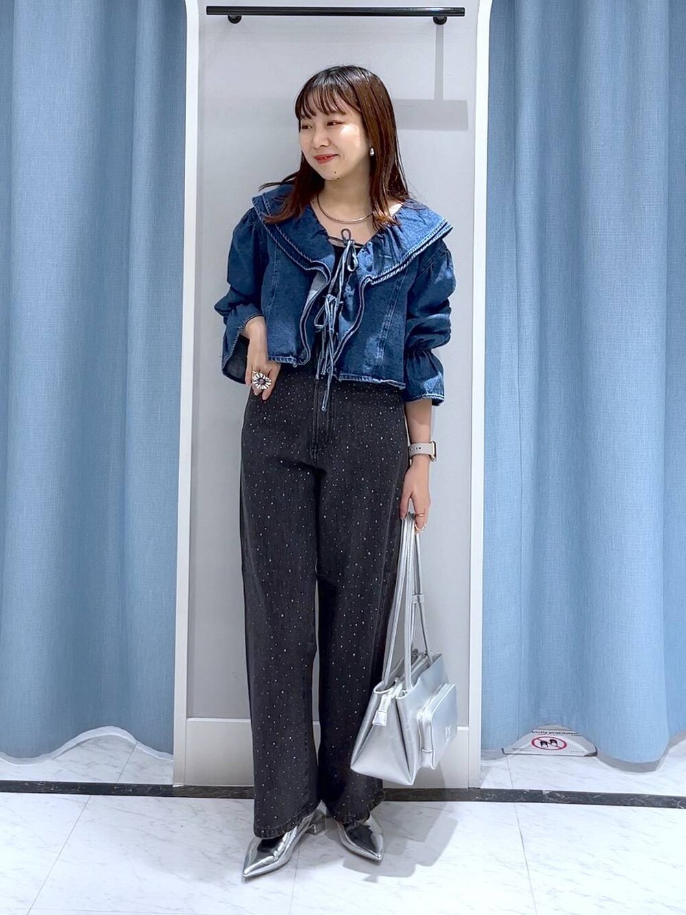 シルバー系のパンプス、ブラック系のデニムパンツ、ブルー系のシャツ/ブラウスを着用したレディースの秋コーディネートの2枚目の写真