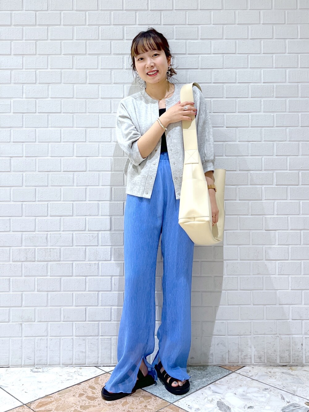 グレー系のカーディガン/ボレロ、ブラック系のトップス、ブルー系のその他パンツを着用したレディースの春コーディネートの2枚目の写真