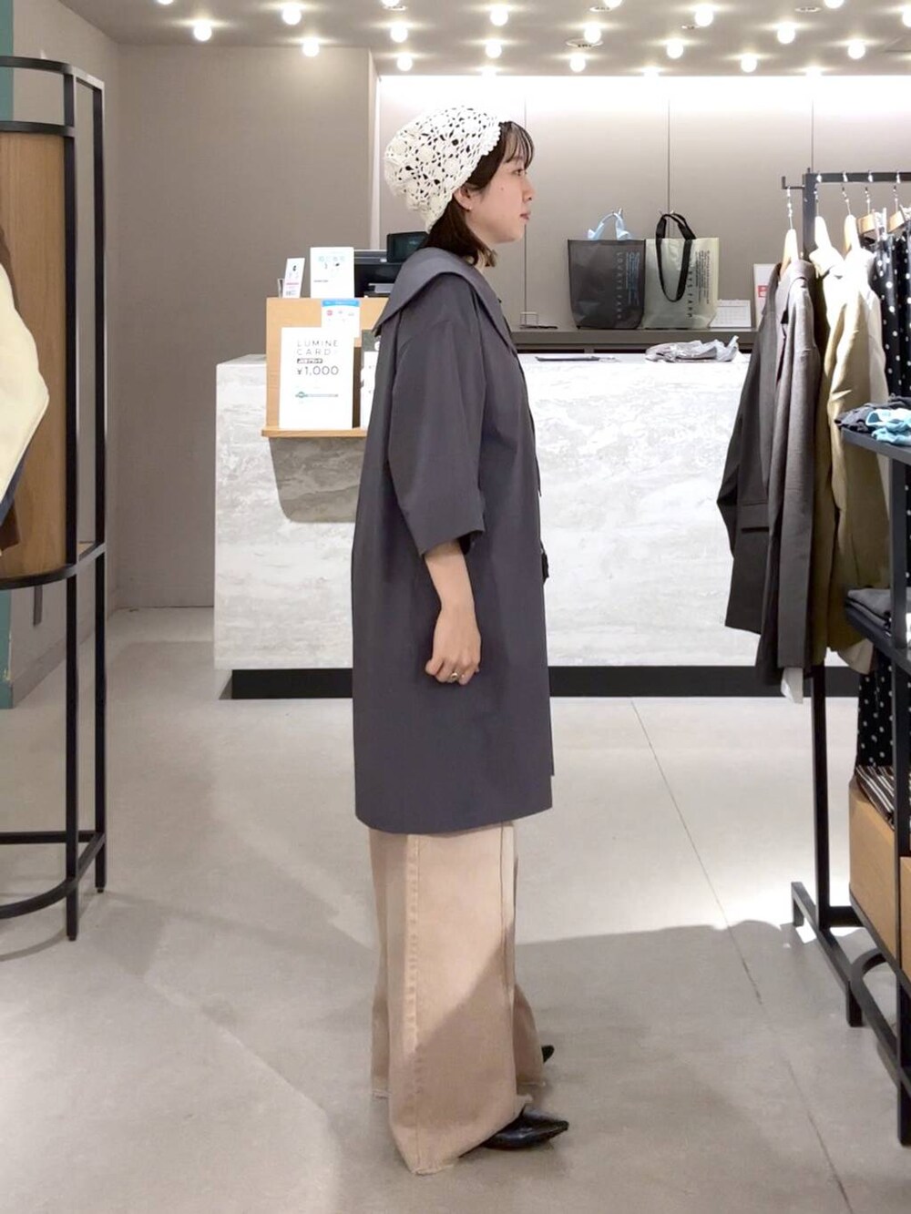 ブラック系のパンプス、オレンジ系のデニムパンツ、ブラック系のボディバッグ/ウエストポーチを着用したレディースの春コーディネートの2枚目の写真