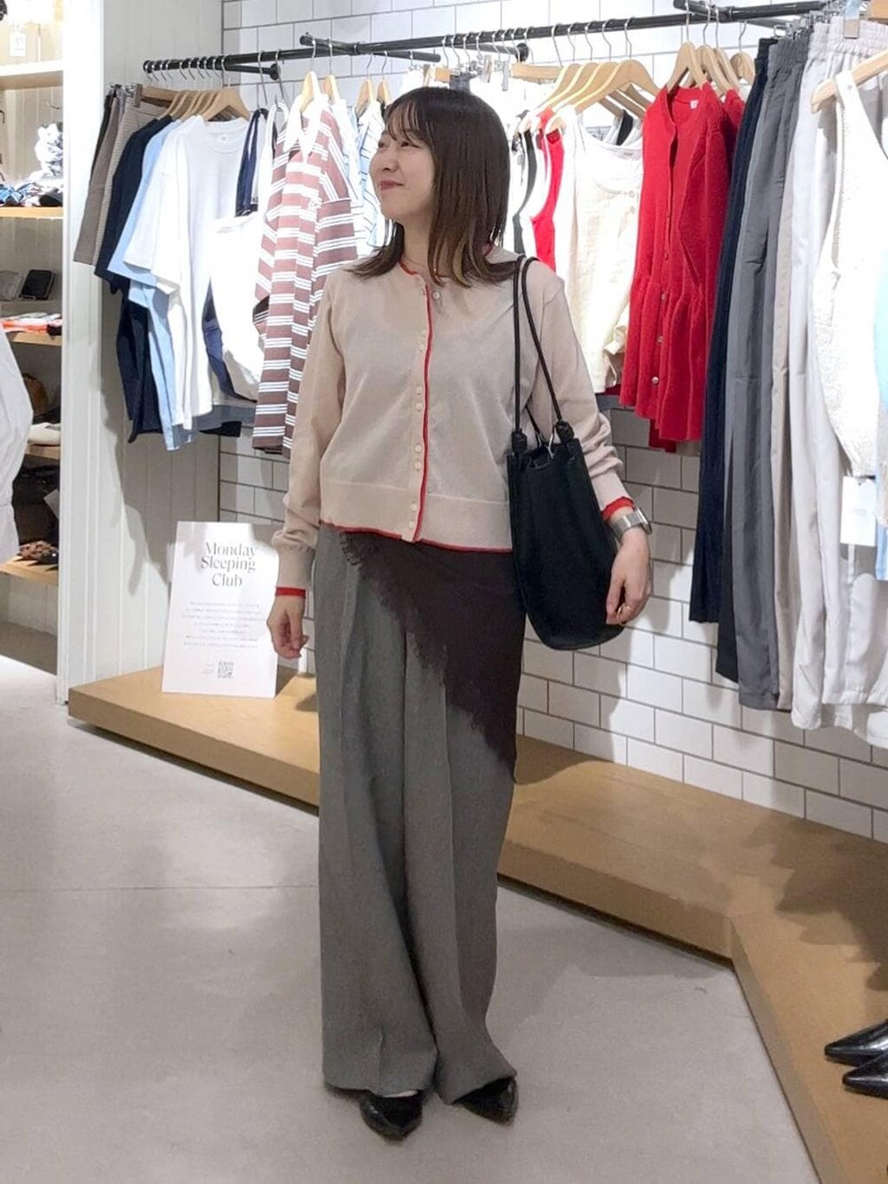 ブラック系のパンプス、グレー系のデニムパンツ、ベージュ系のカーディガン/ボレロを着用したレディースの春コーディネートの2枚目の写真