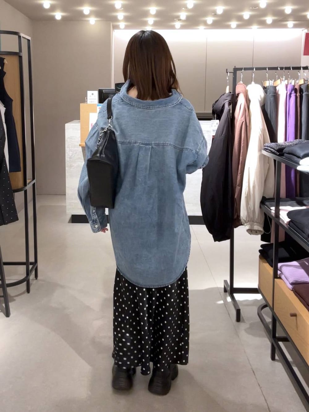 ブラック系のスカート、ブルー系のシャツ/ブラウス、ブラック系のショルダーバッグを着用したレディースの冬コーディネートの3枚目の写真