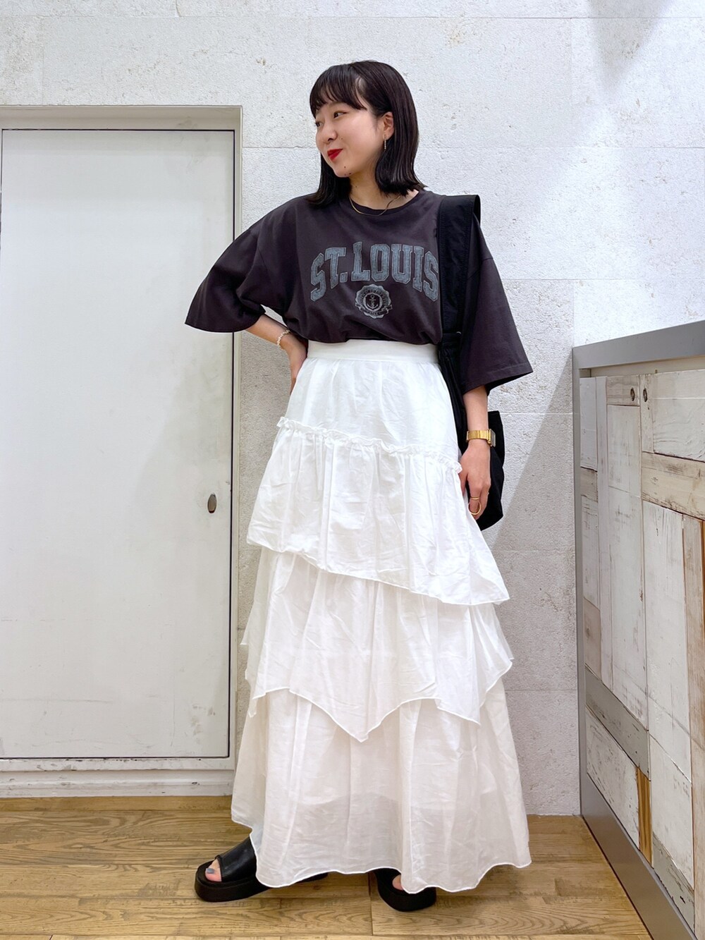 ホワイト系のスカート、グレー系のTシャツ/カットソー、ブラック系のバッグを着用したレディースの夏コーディネートの2枚目の写真