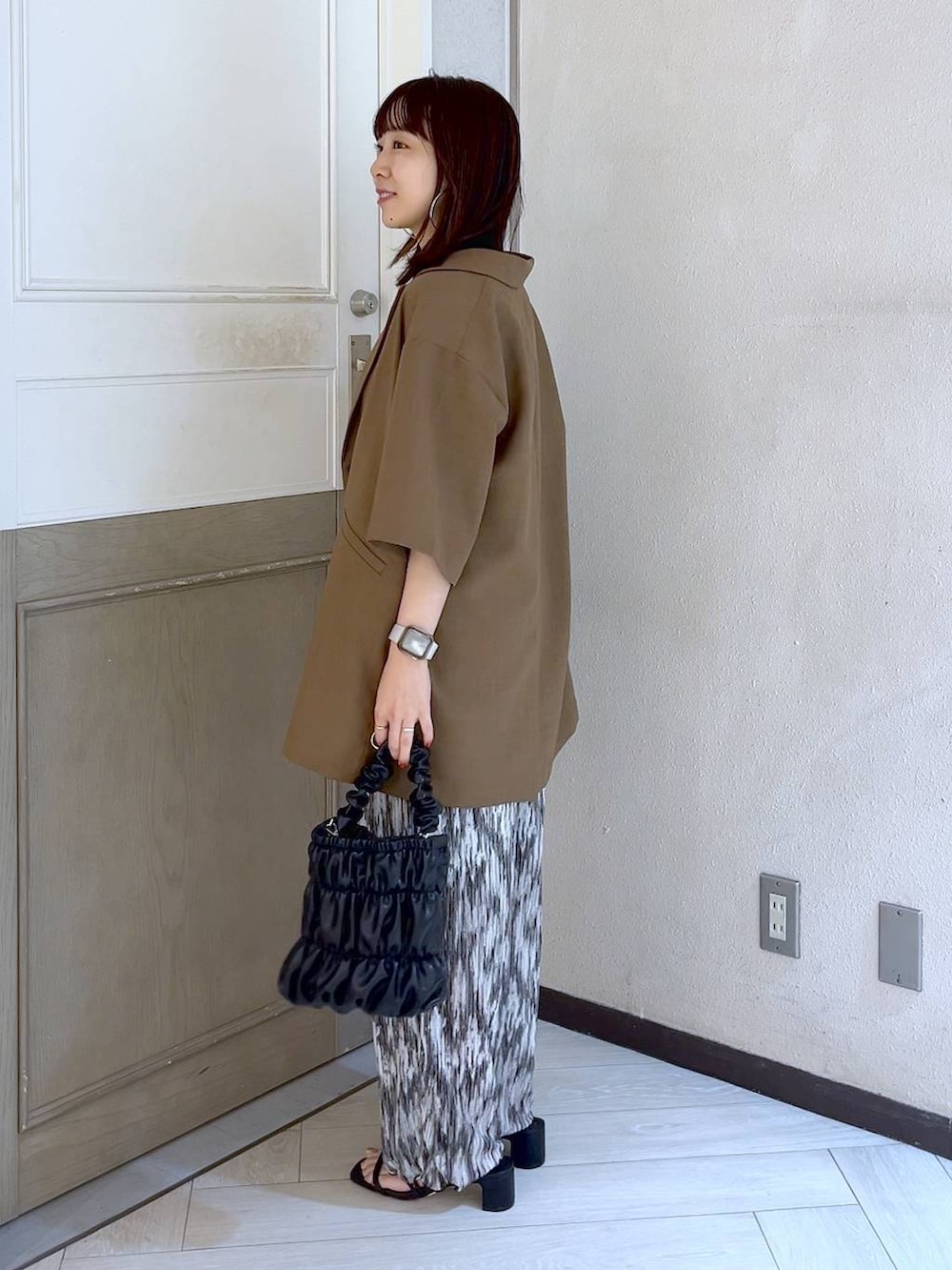 ホワイト系のTシャツ/カットソー、ブラック系のサンダル、ブラック系のショルダーバッグを着用したレディースの夏コーディネートの2枚目の写真