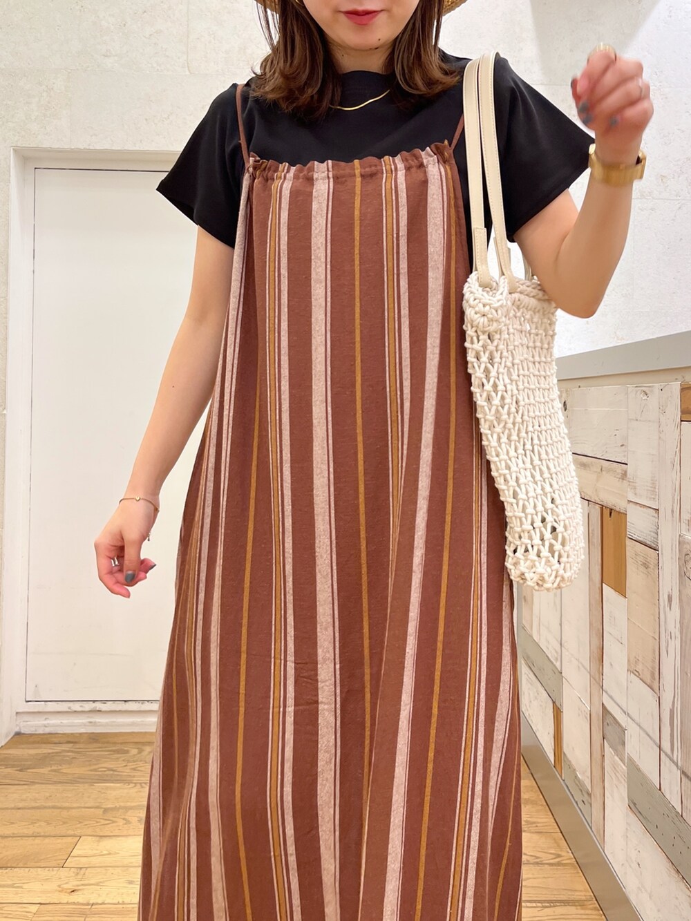 ブラック系のTシャツ/カットソー、ブラウン系のワンピース、ホワイト系のトートバッグを着用したレディースの春コーディネートの4枚目の写真