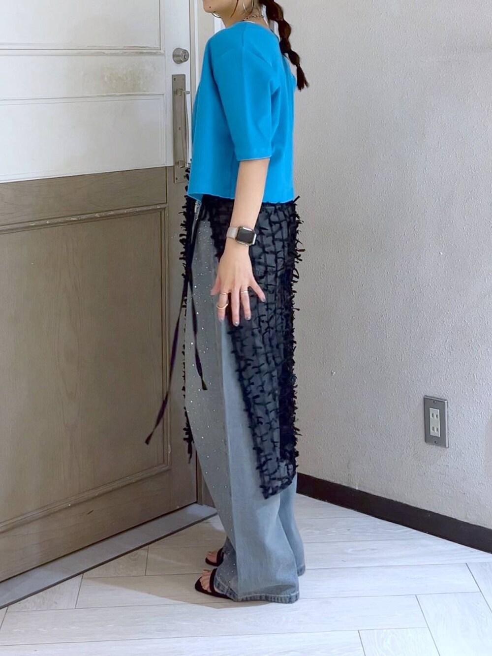 ブラック系のサンダル、ブルー系のデニムパンツ、ブラック系のショルダーバッグを着用したレディースの夏コーディネートの4枚目の写真