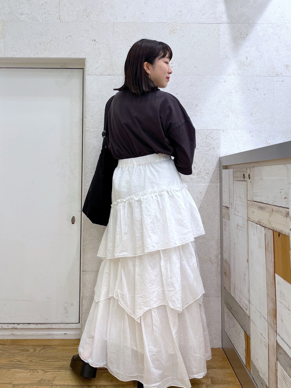 ホワイト系のスカート、グレー系のTシャツ/カットソー、ブラック系のバッグを着用したレディースの夏コーディネートの3枚目の写真