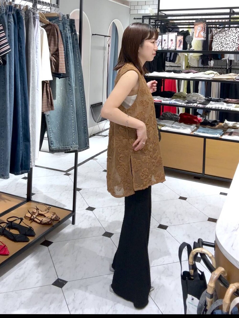 シルバー系のサンダル、ブラック系のその他パンツ、ブラウン系のベストを着用したレディースの夏コーディネートの2枚目の写真