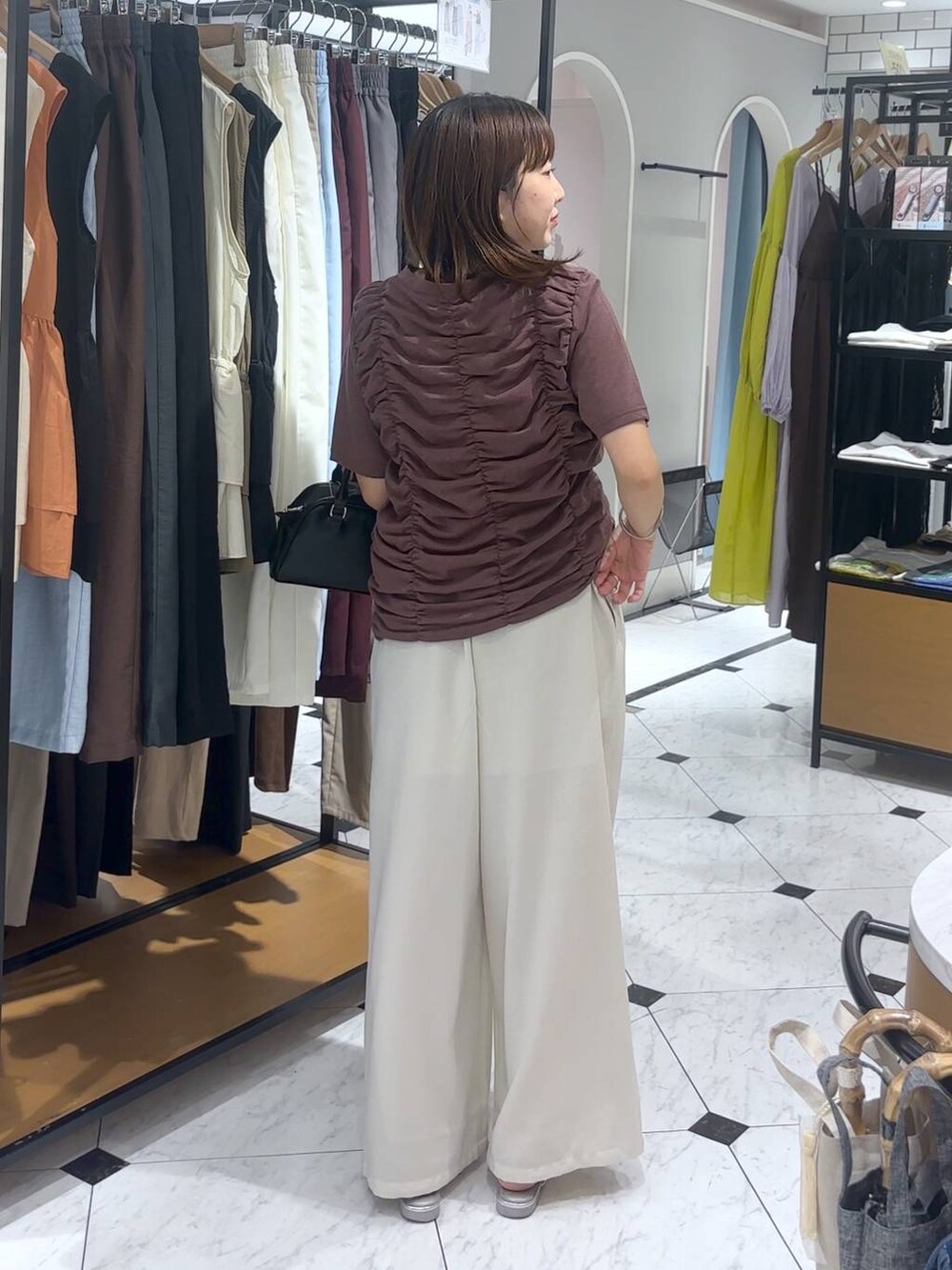 ホワイト系のその他パンツ、シルバー系のサンダル、ブラック系のショルダーバッグを着用したレディースの夏コーディネートの3枚目の写真