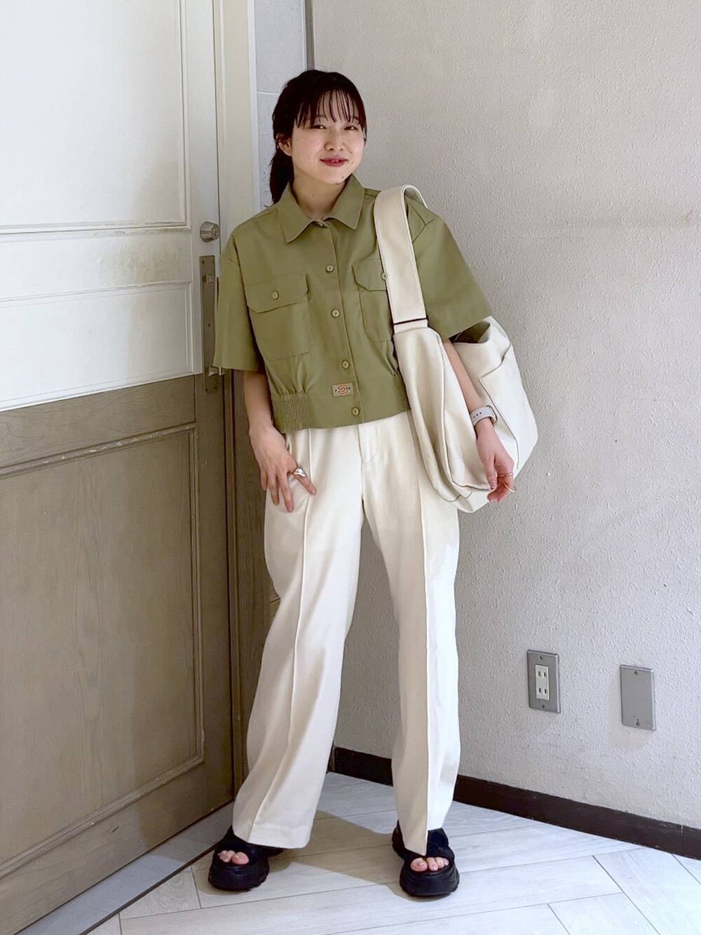 ブラック系のサンダル、ホワイト系のボディバッグ/ウエストポーチ、ホワイト系のスラックスを着用したレディースの春コーディネートの4枚目の写真