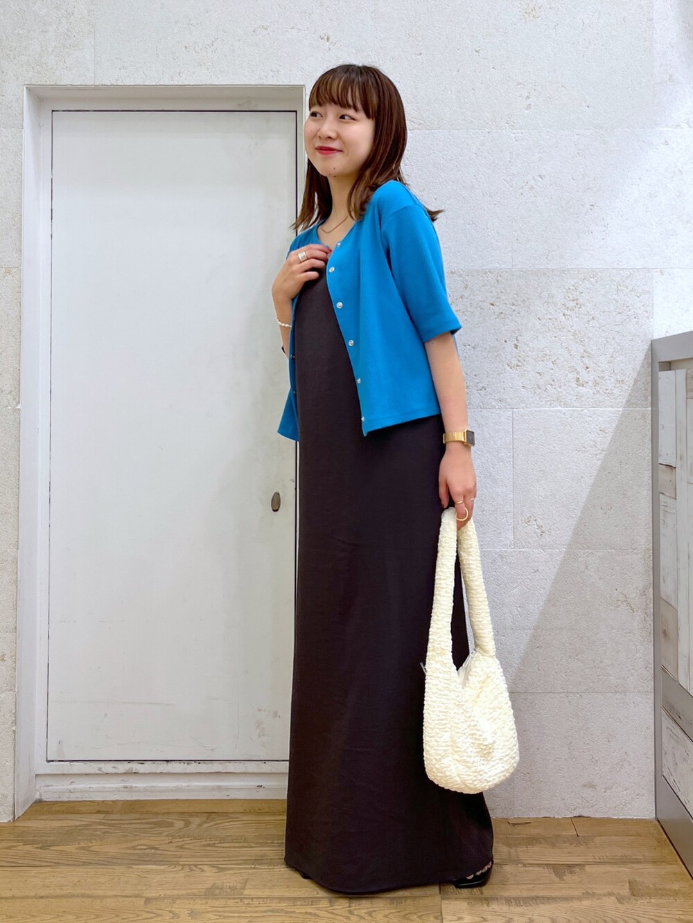 グレー系のワンピース、ブルー系のカーディガン/ボレロ、ホワイト系のハンドバッグを着用したレディースの夏コーディネートの2枚目の写真