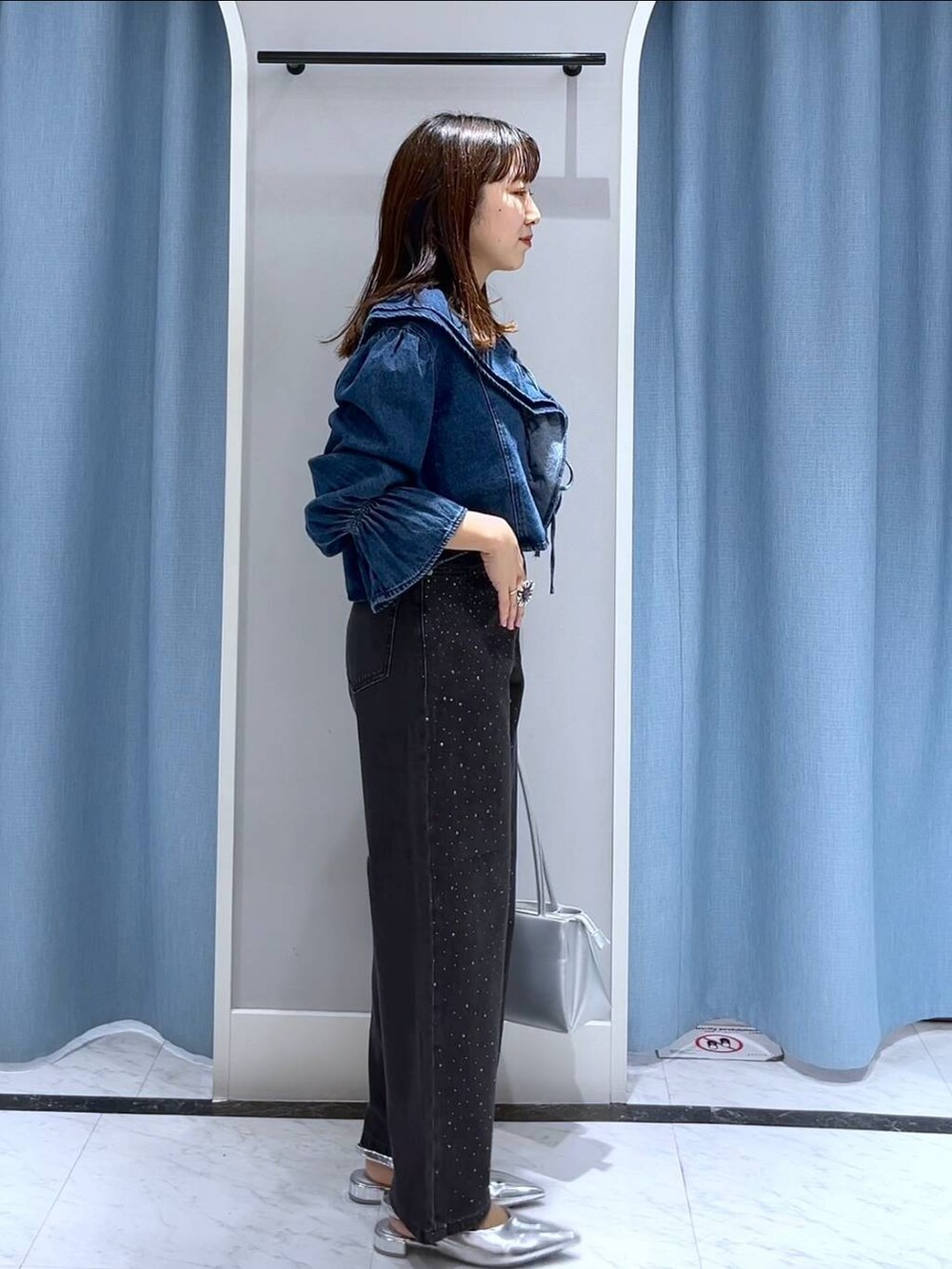 シルバー系のパンプス、ブラック系のデニムパンツ、ブルー系のシャツ/ブラウスを着用したレディースの秋コーディネートの3枚目の写真