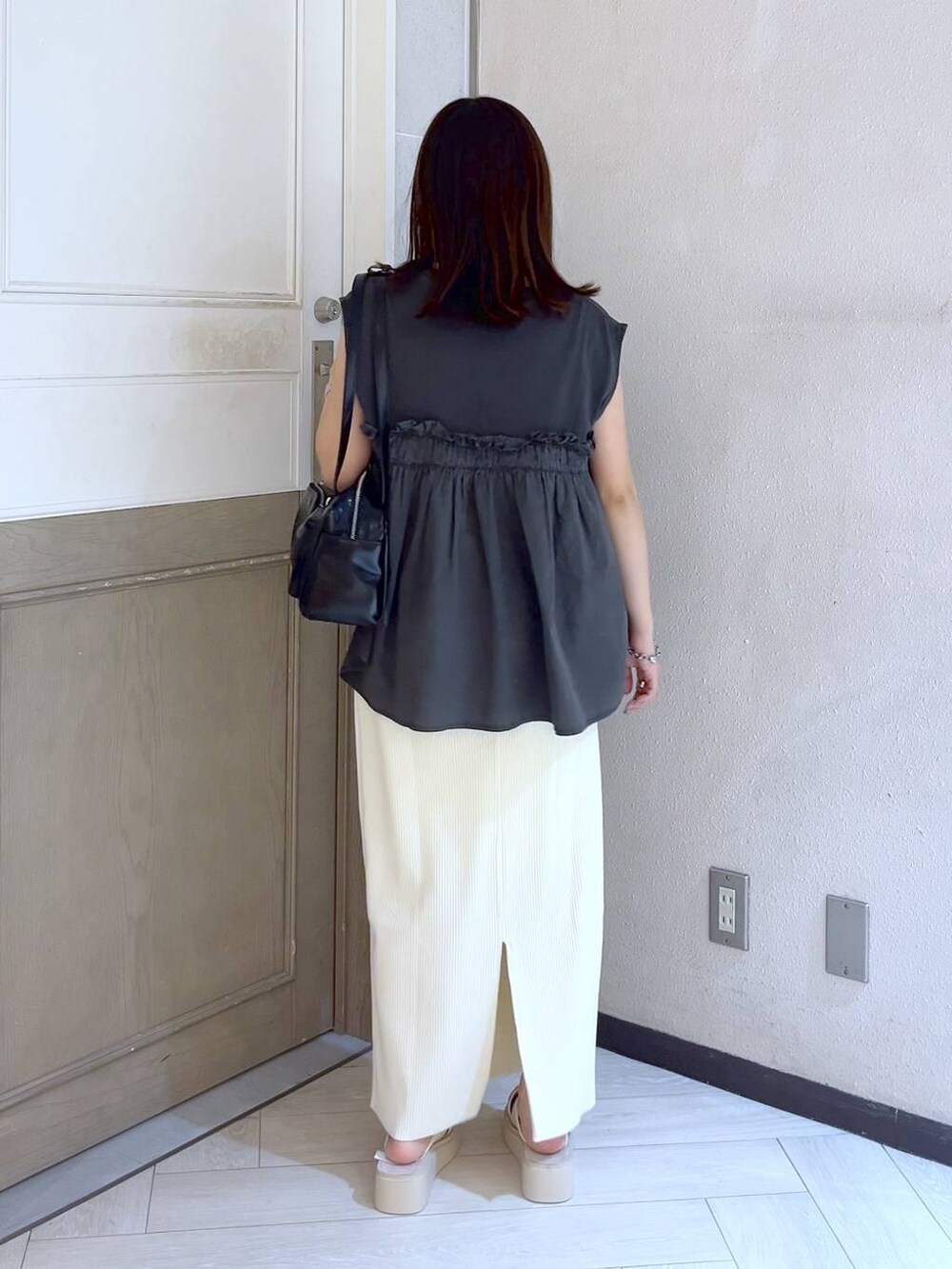 ホワイト系のスカート、ホワイト系のサンダル、ブラック系のボストンバッグを着用したレディースの夏コーディネートの4枚目の写真