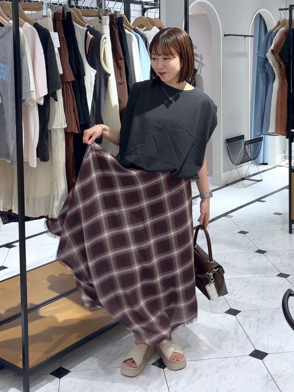 ホワイト系のサンダル、ブラウン系のボストンバッグ、グレー系のTシャツ/カットソーを着用したレディースの夏コーディネートの4枚目の写真