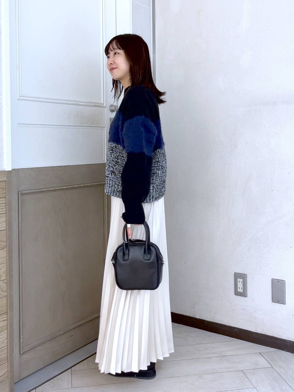 ブラック系のニット/セーター、ブラック系のブーツ、ブラック系のボストンバッグを着用したレディースの冬コーディネートの3枚目の写真