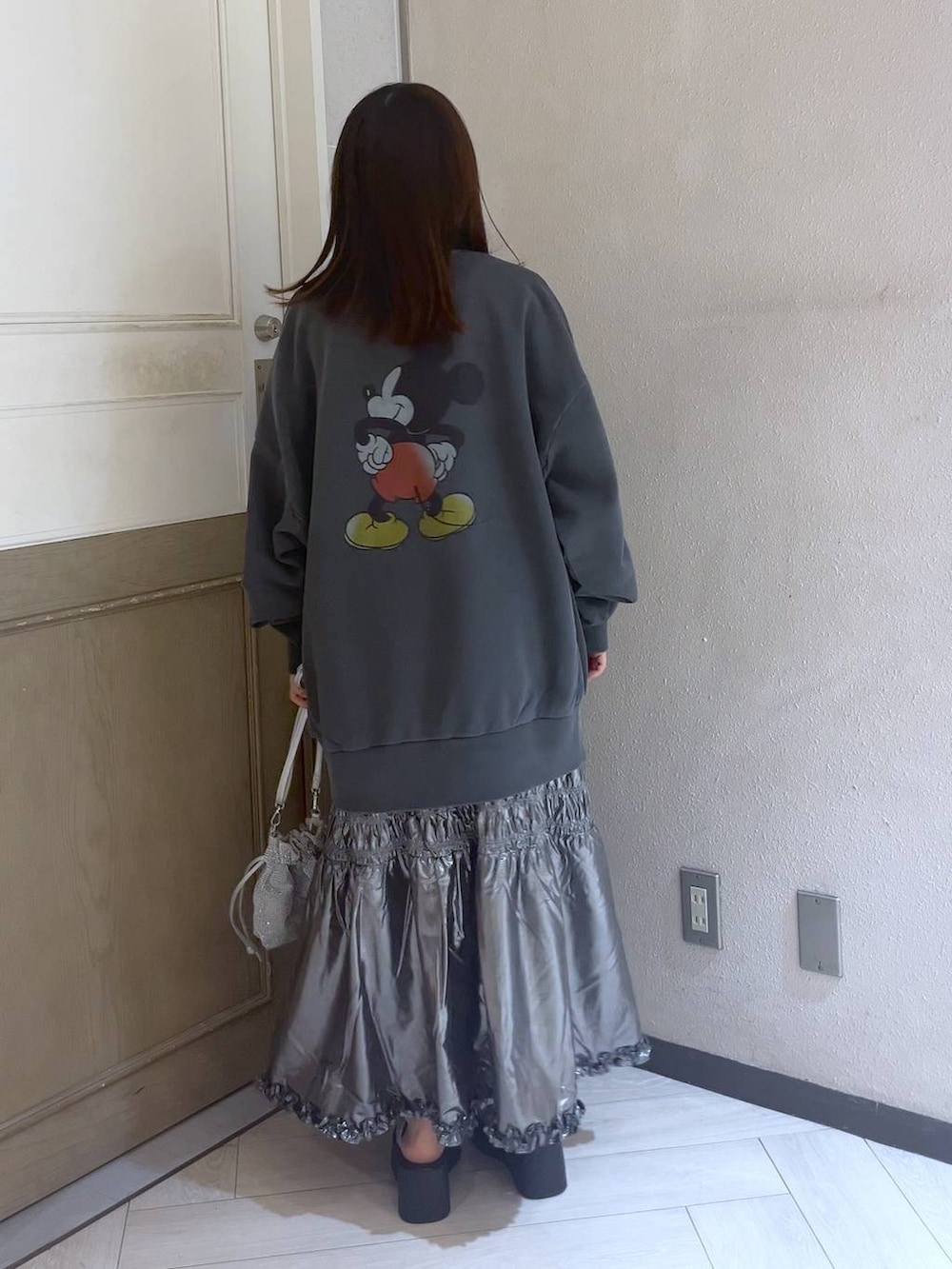 シルバー系のサンダル、シルバー系のショルダーバッグ、シルバー系のスカートを着用したレディースの夏コーディネートの3枚目の写真