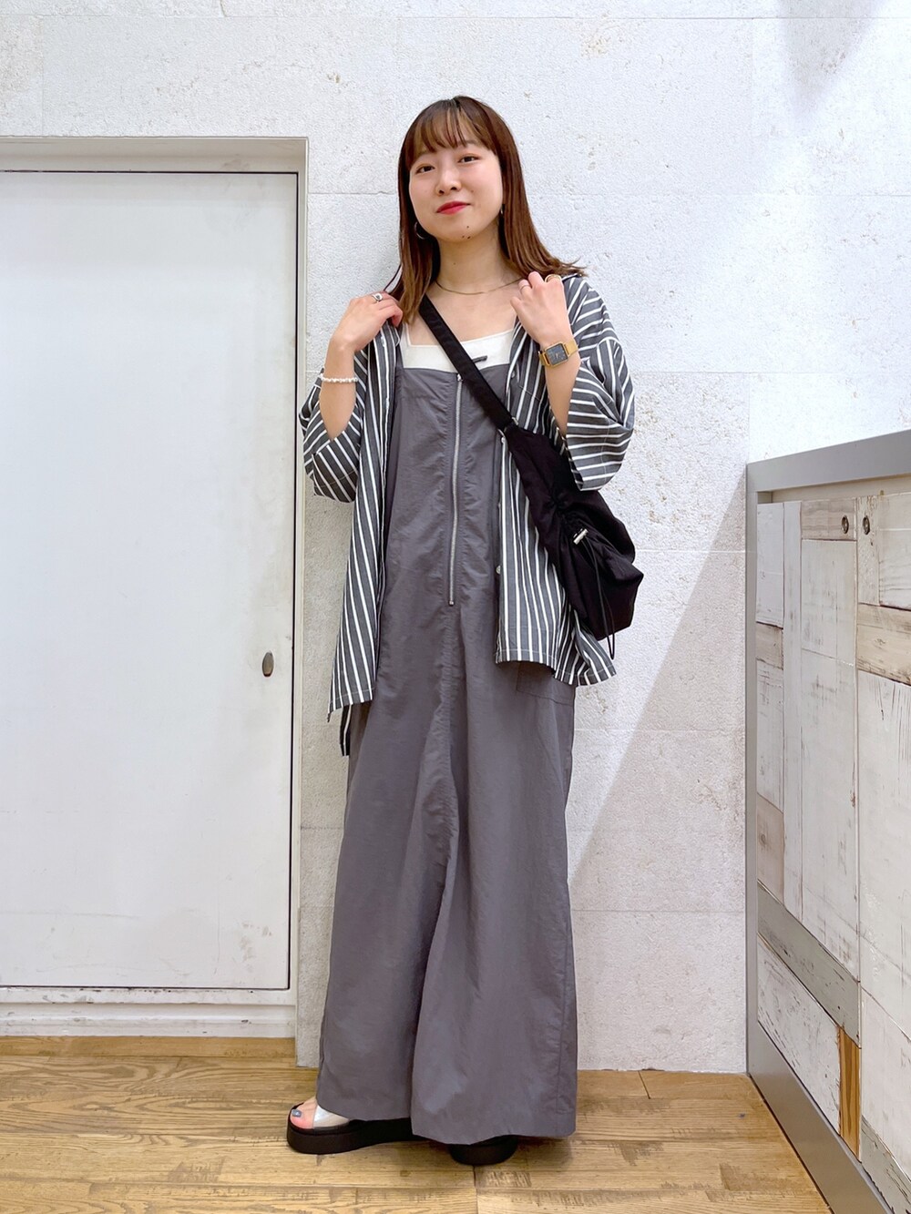 グレー系のワンピース、ブラック系のトップス、ブラック系のショルダーバッグを着用したレディースの夏コーディネートの4枚目の写真