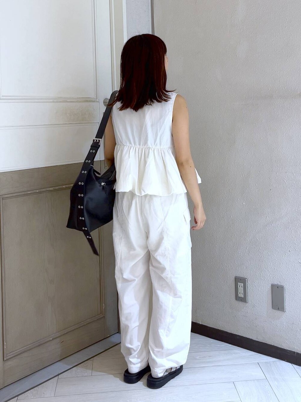 ホワイト系のカーゴパンツ、ホワイト系のベスト、シルバー系のスニーカーを着用したレディースの夏コーディネートの4枚目の写真