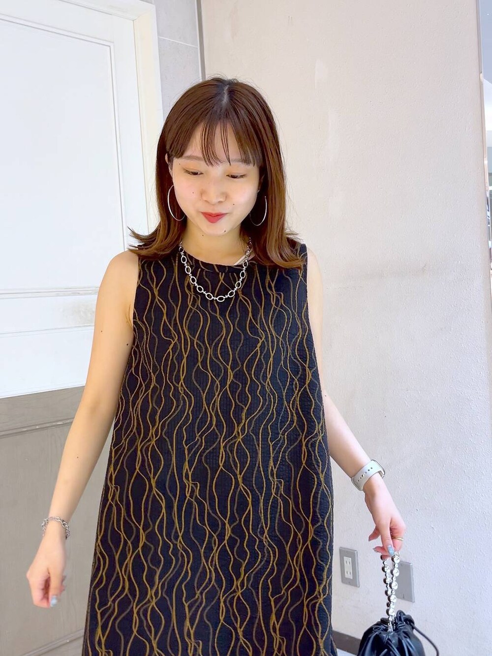 ブラック系のショルダーバッグ、ブラック系のサンダル、ブラック系のワンピースを着用したレディースの夏コーディネートの4枚目の写真