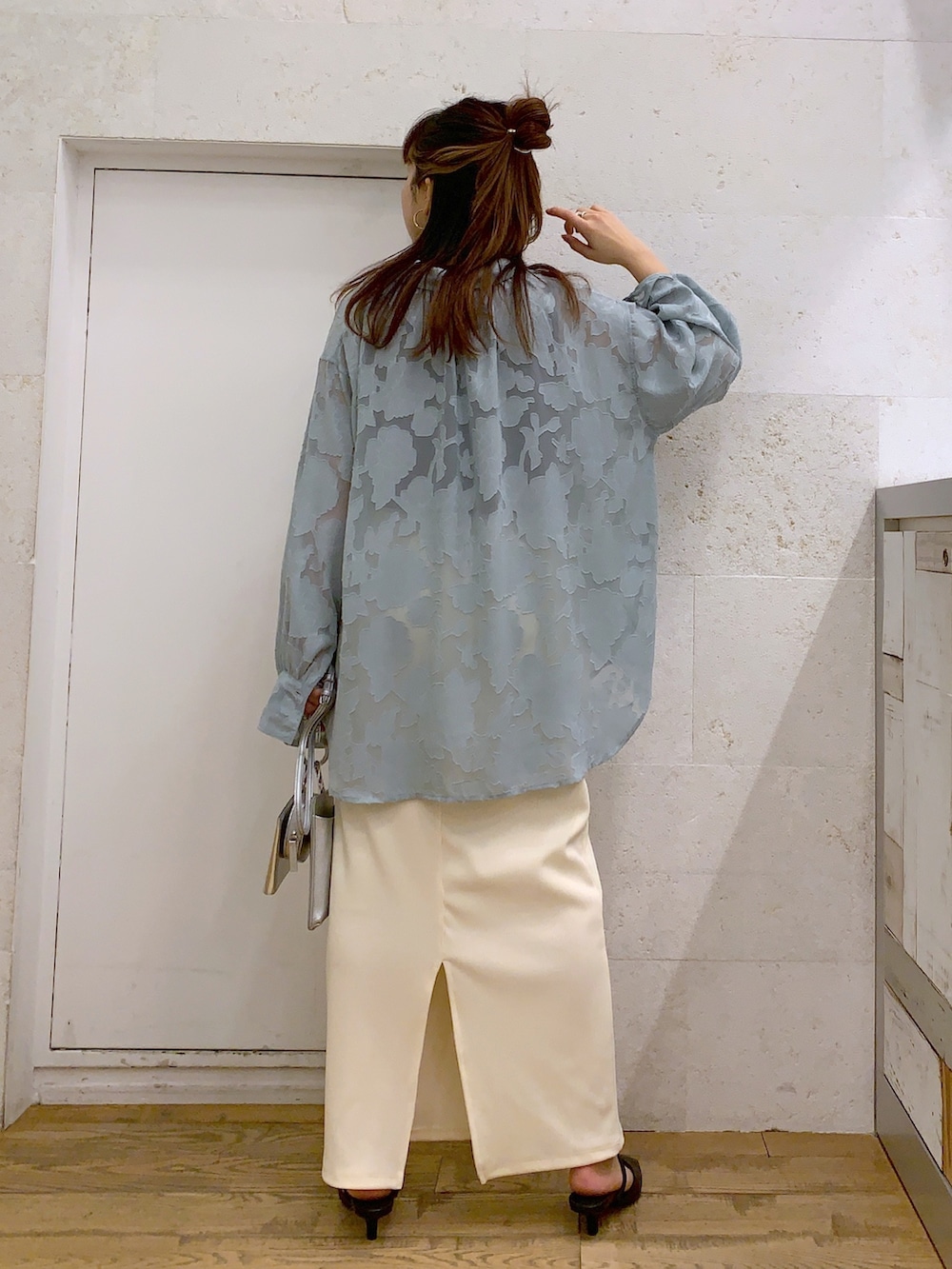 グリーン系のトップス、ブラック系のトップス、ホワイト系のスカートを着用したレディースの春コーディネートの2枚目の写真