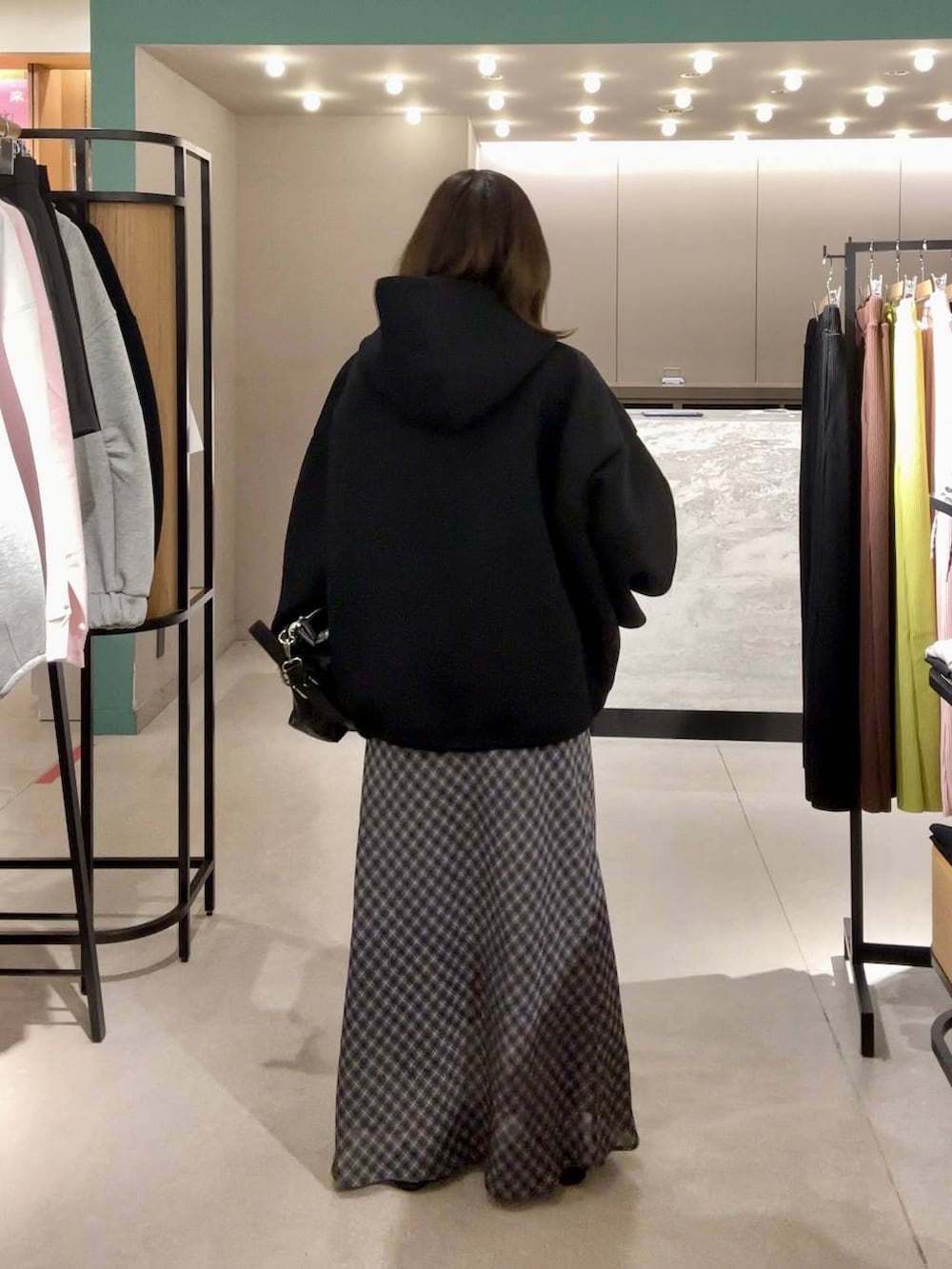 ブラック系のパンプス、ブラック系のショルダーバッグ、ブラック系のブルゾンを着用したレディースの冬コーディネートの3枚目の写真