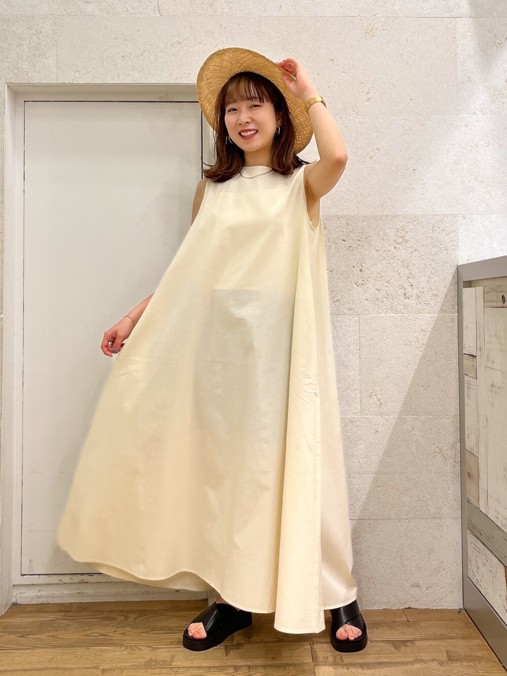 ホワイト系のワンピース、ブラック系のシューズ、ベージュ系の帽子を着用したレディースの春コーディネートの2枚目の写真