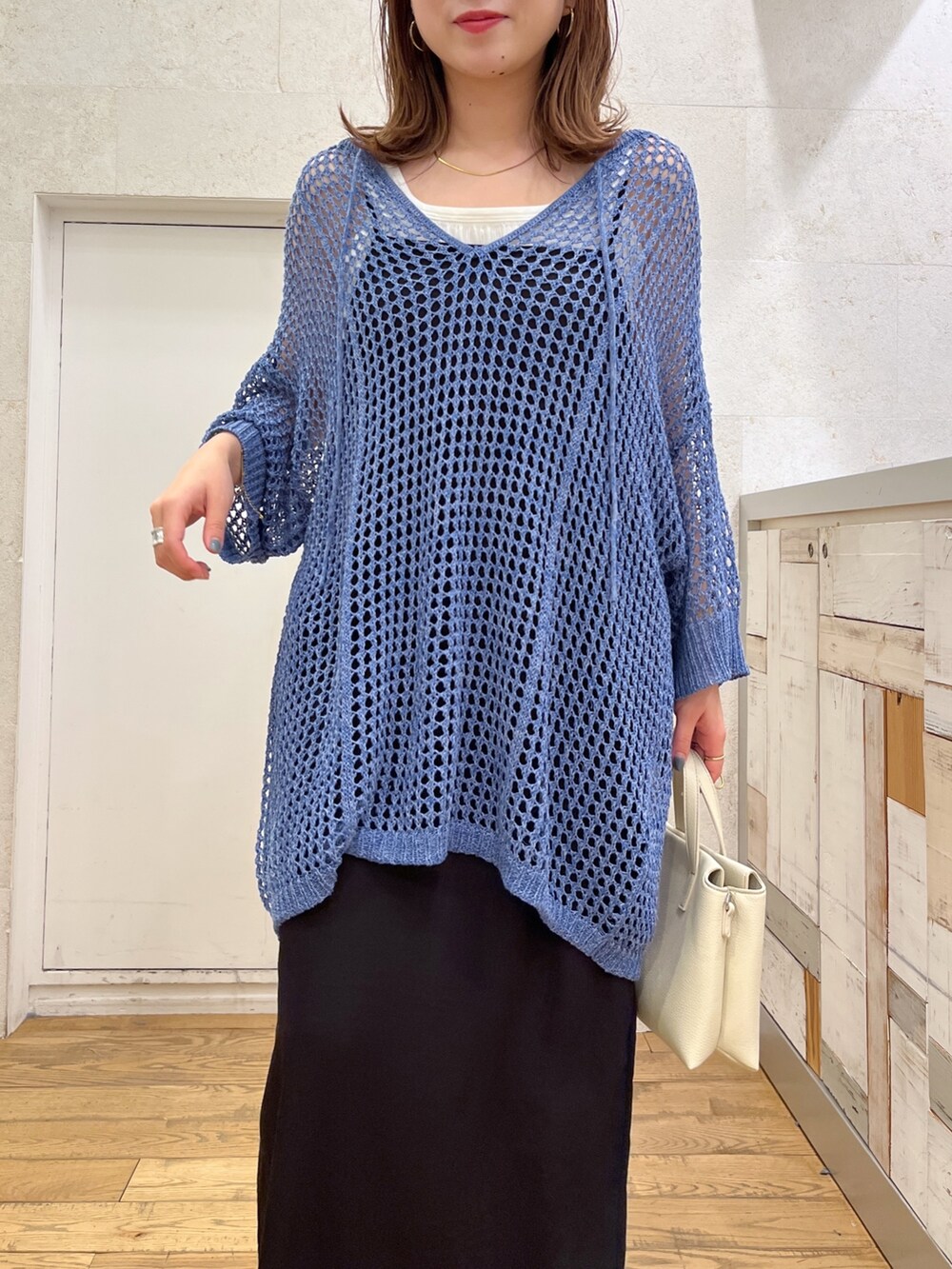 ホワイト系のトップス、ブルー系のトップス、ブラック系のワンピースを着用したレディースの春コーディネートの2枚目の写真