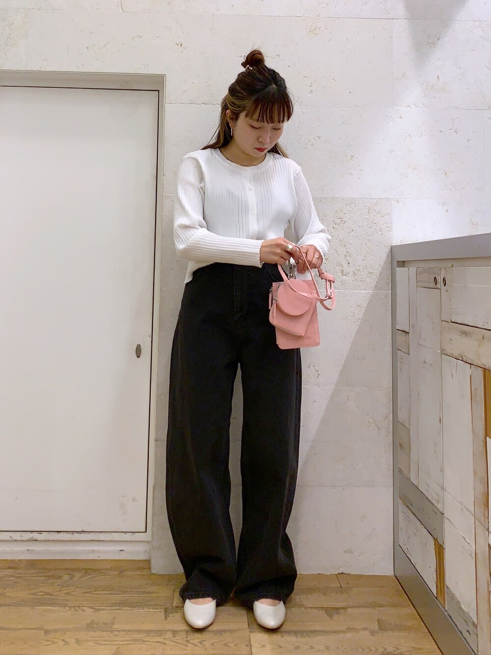 ホワイト系のトップス、ブラック系のパンツ、ピンク系のショルダーバッグを着用したレディースの春コーディネートの3枚目の写真