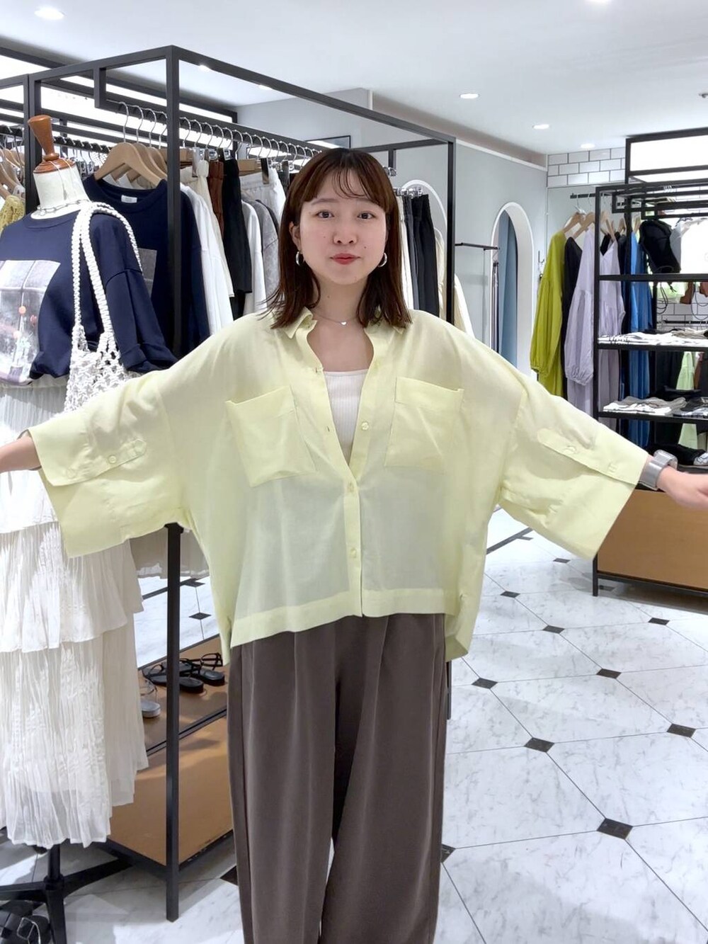 ホワイト系のTシャツ/カットソー、ブラウン系のデニムパンツ、イエロー系のシャツ/ブラウスを着用したレディースの春コーディネートの4枚目の写真