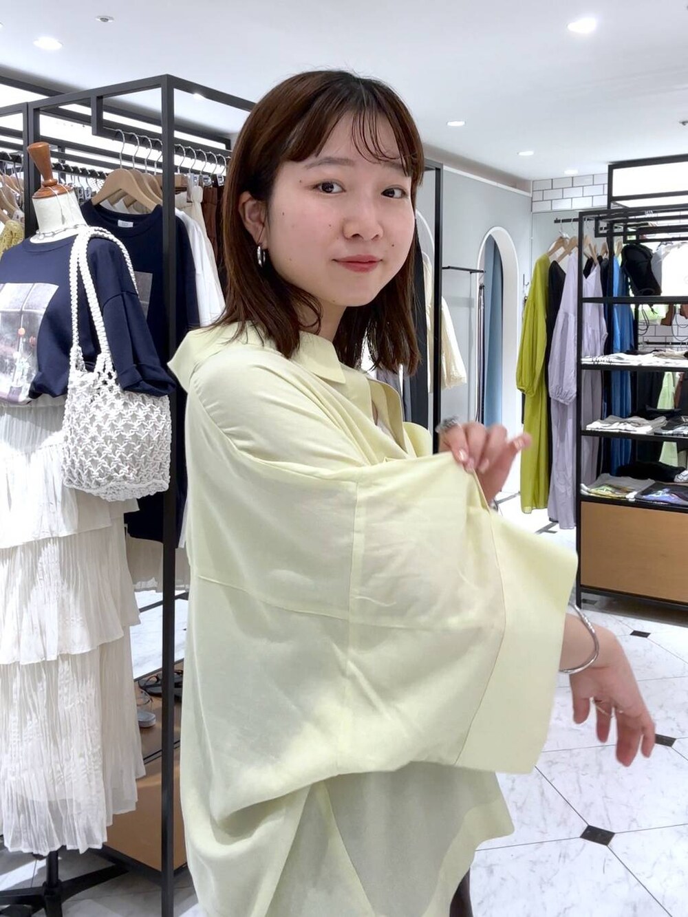 ホワイト系のTシャツ/カットソー、ブラウン系のデニムパンツ、イエロー系のシャツ/ブラウスを着用したレディースの春コーディネートの6枚目の写真