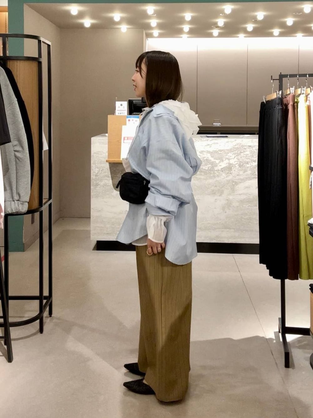 ベージュ系のその他パンツ、ホワイト系のシャツ/ブラウス、ブラック系のパンプスを着用したレディースの冬コーディネートの2枚目の写真