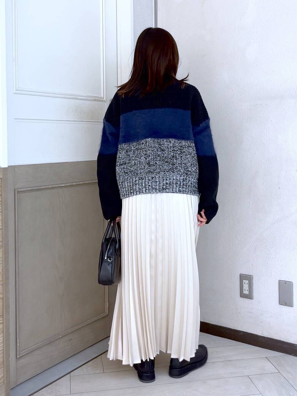 ブラック系のニット/セーター、ブラック系のブーツ、ブラック系のボストンバッグを着用したレディースの冬コーディネートの4枚目の写真