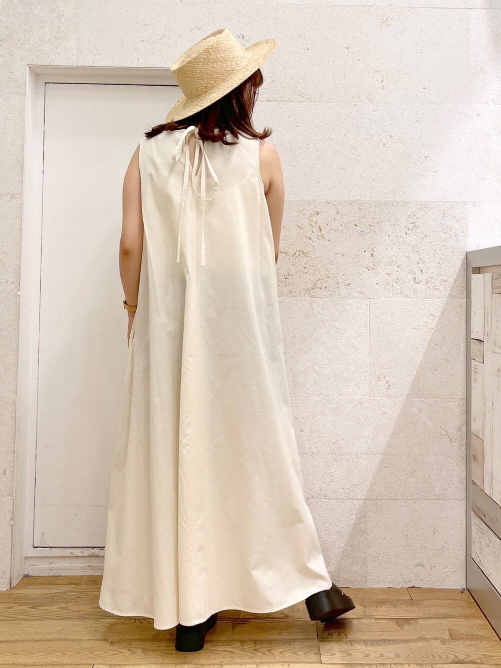 ホワイト系のワンピース、ブラック系のシューズ、ベージュ系の帽子を着用したレディースの春コーディネートの3枚目の写真