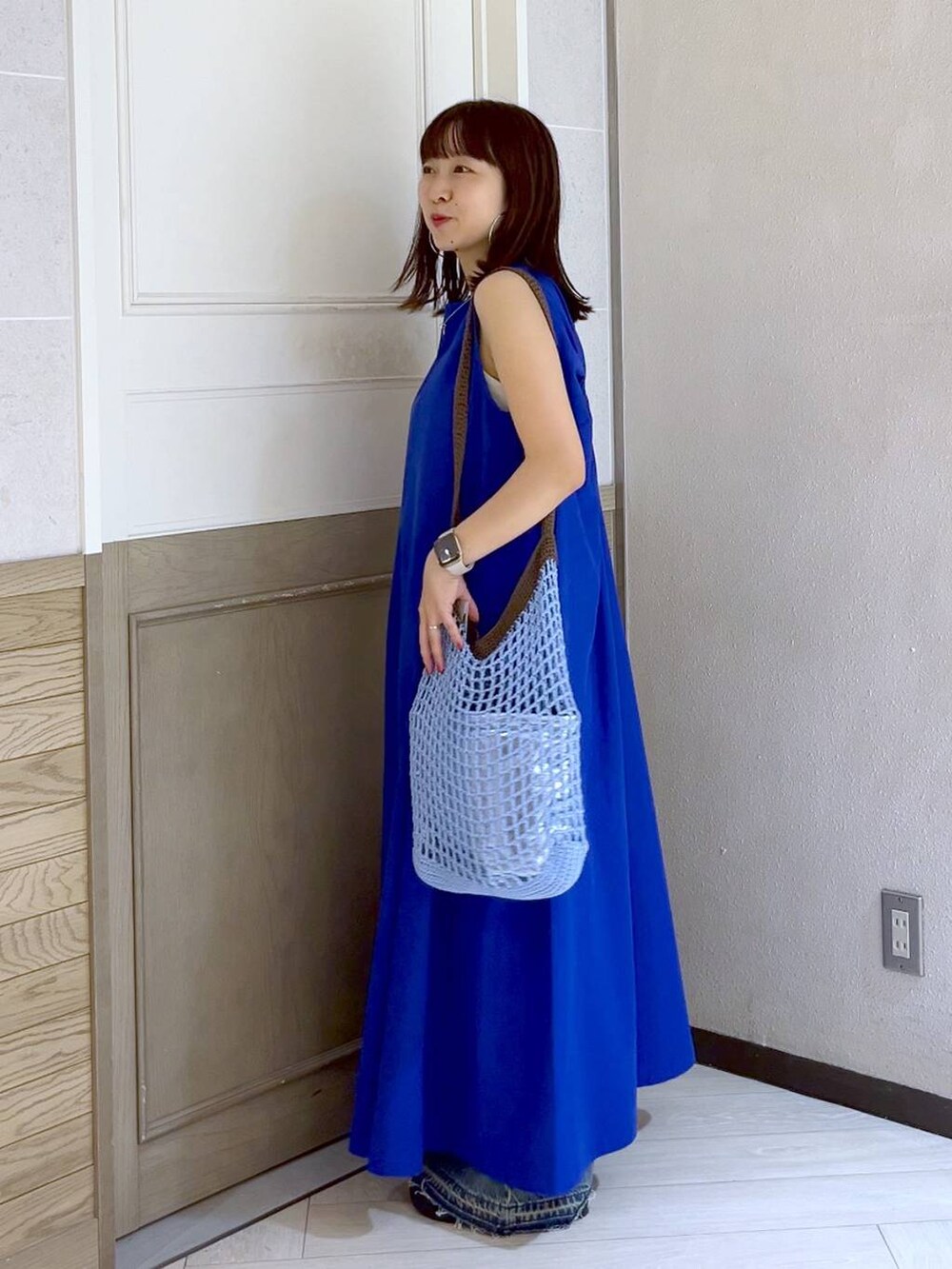 ブルー系のショルダーバッグ、ブルー系のワンピース、シルバー系のスニーカーを着用したレディースの夏コーディネートの3枚目の写真