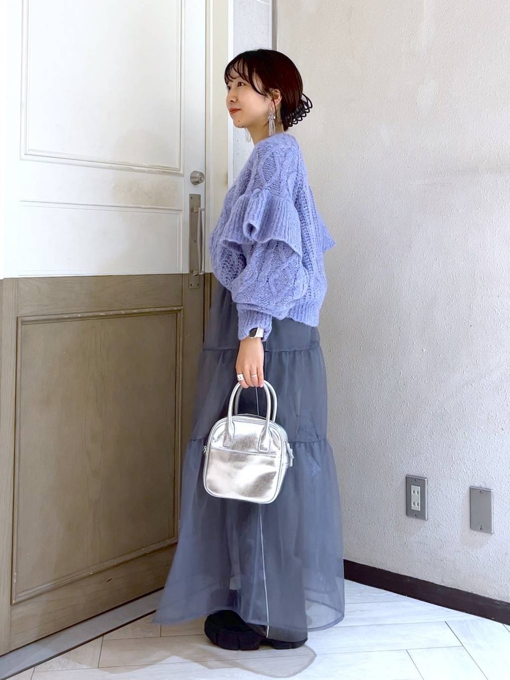 ブラック系のブーツ、パープル系のニット/セーター、シルバー系のボストンバッグを着用したレディースの秋コーディネートの3枚目の写真